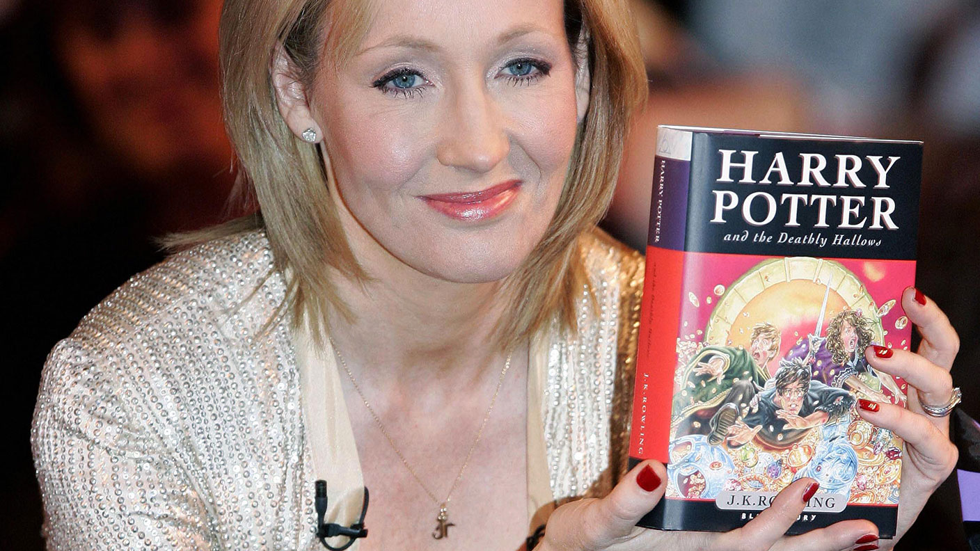 .K. Rowling holds a copy of &quot;Harry Potter and the Deathly Hallows&quot; SHAUN CURRY/AFP via Getty Images