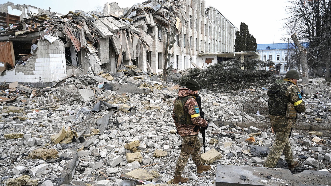 Ukrainian soldiers near a bombed-out school building