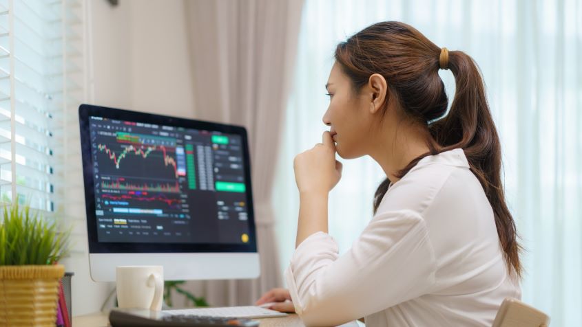 Woman using a desktop computer to trade stocks