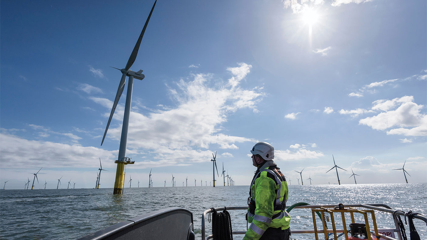 Man on a boat looking at a windfarm 