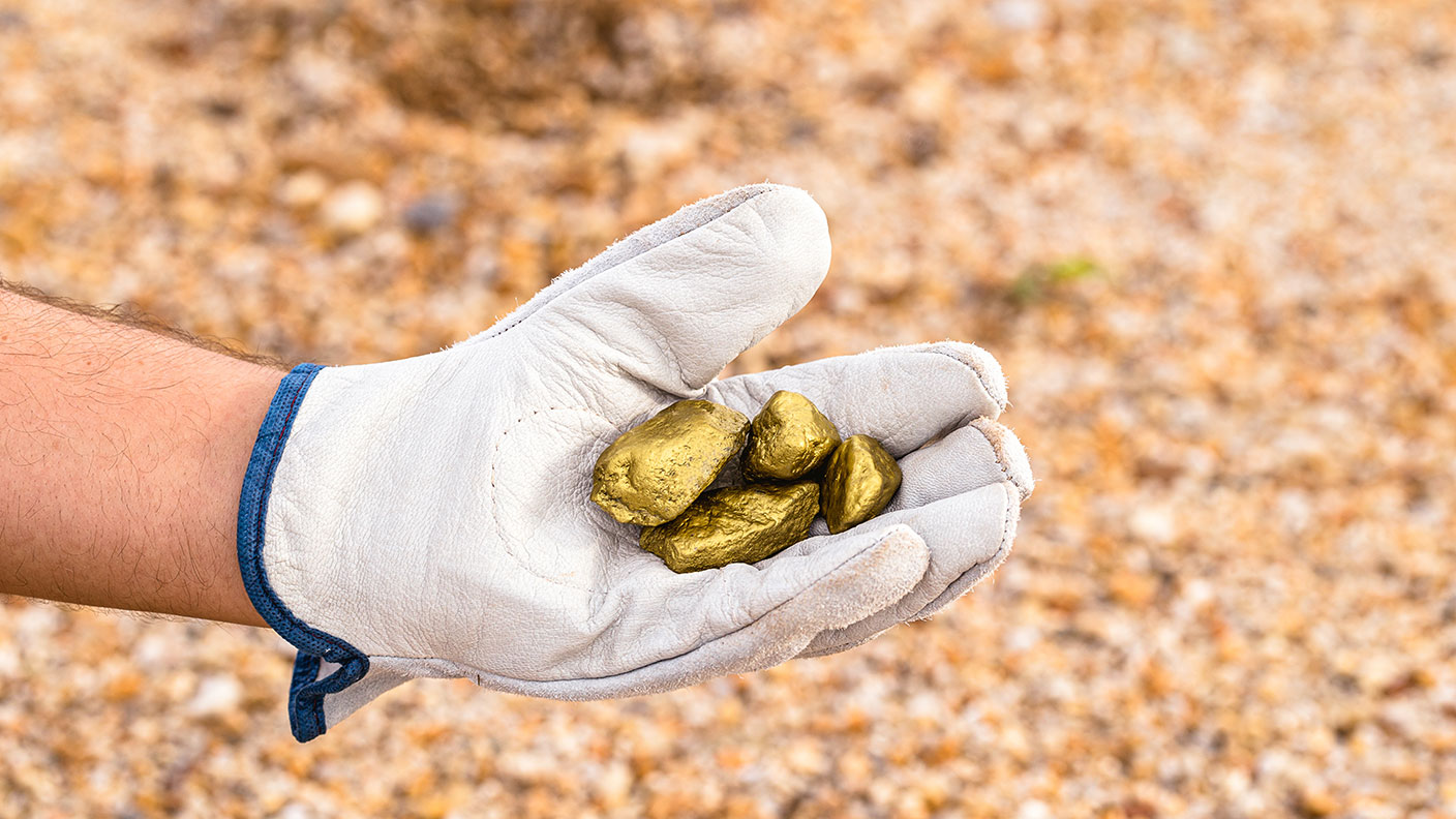 Hand holding golden stones 