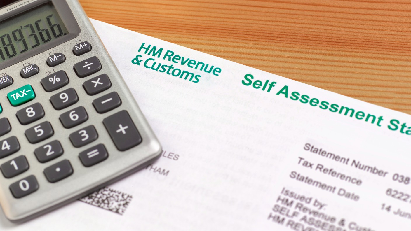 A calculator on top of a self assessment tax form