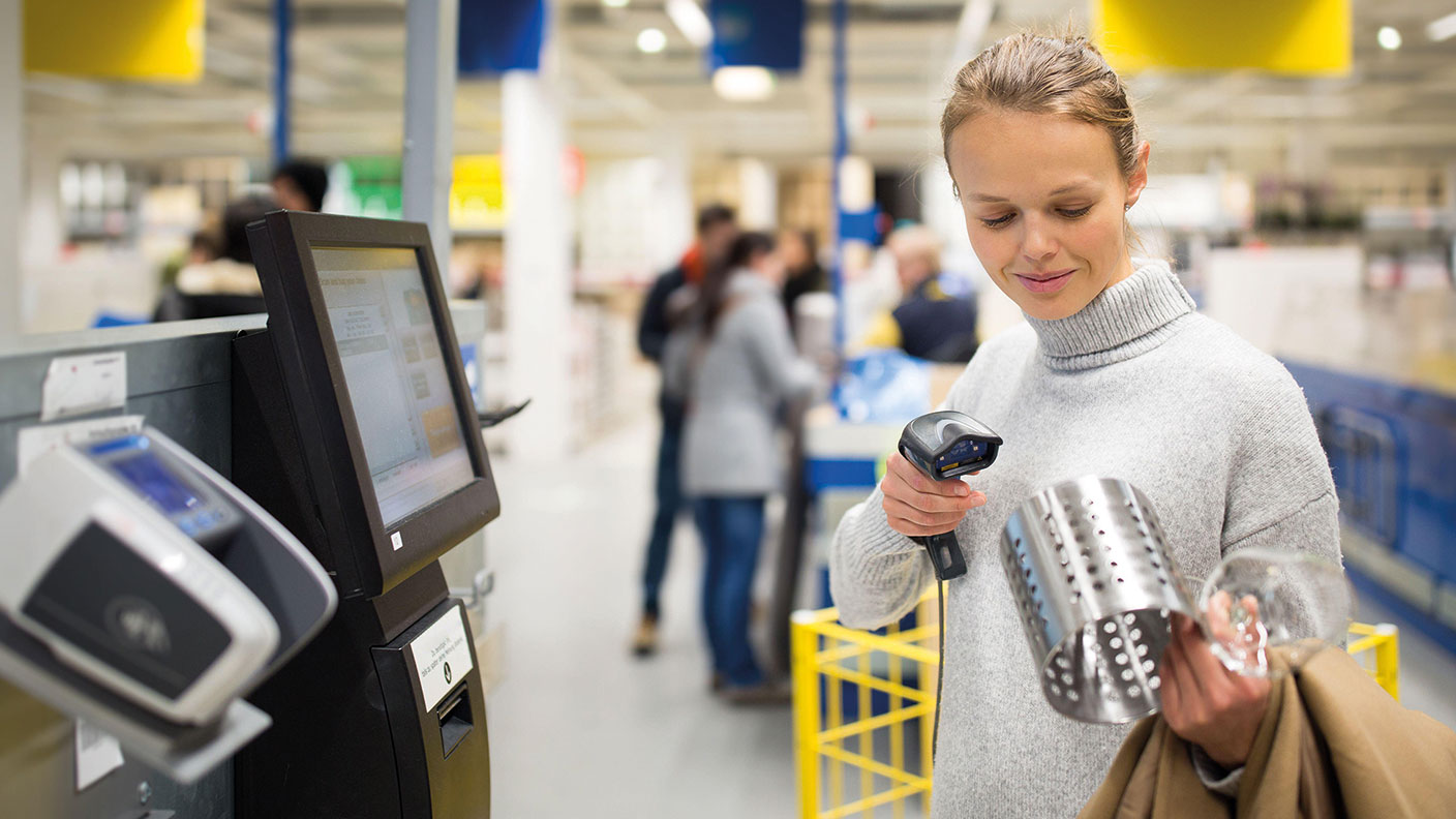 Woman scanning something at a self-service till 