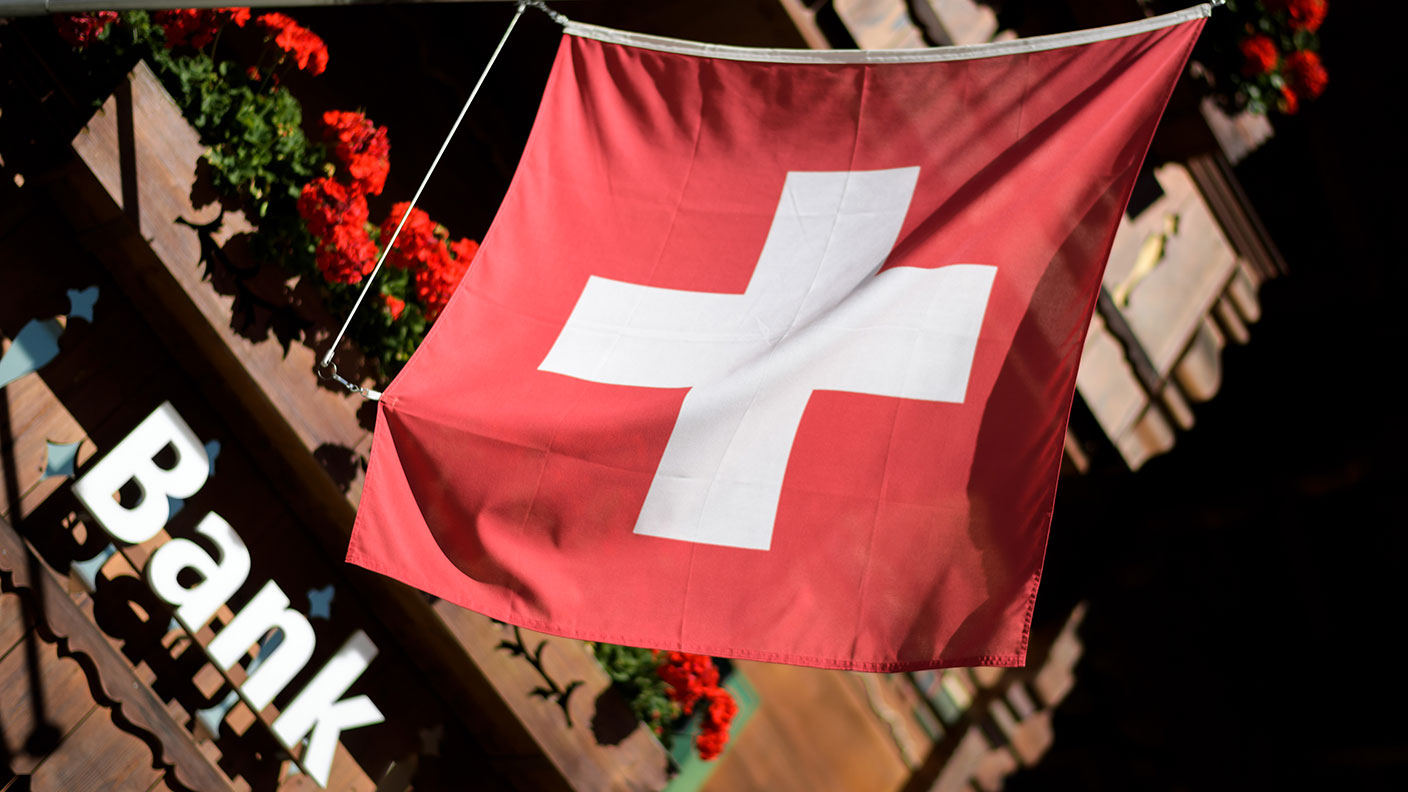 Swiss flag and bank © FABRICE COFFRINI/AFP via Getty Images