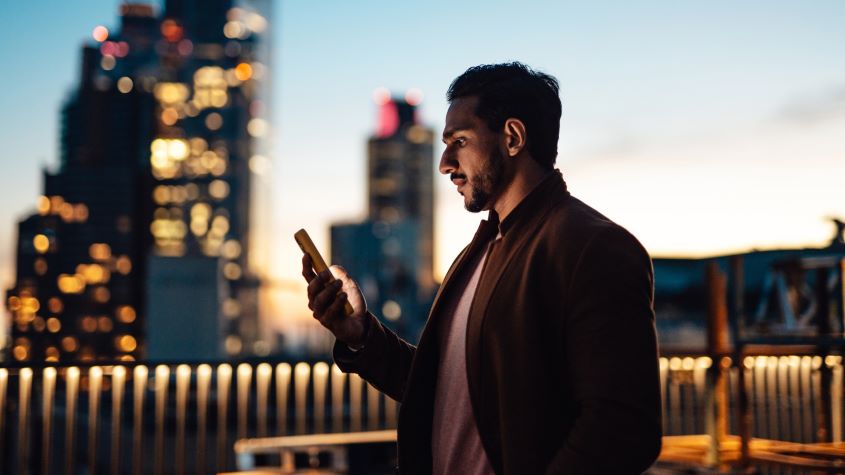Man using mobile phone on rooftop at night