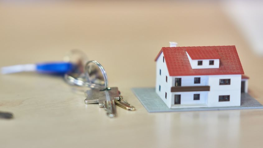 Set of keys and a model house on a table