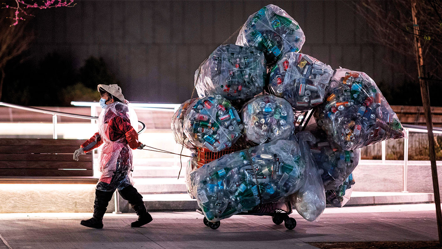 A woman pulling a trolley loaded with bags of recyclables © JOHANNES EISELE/AFP via Getty Images