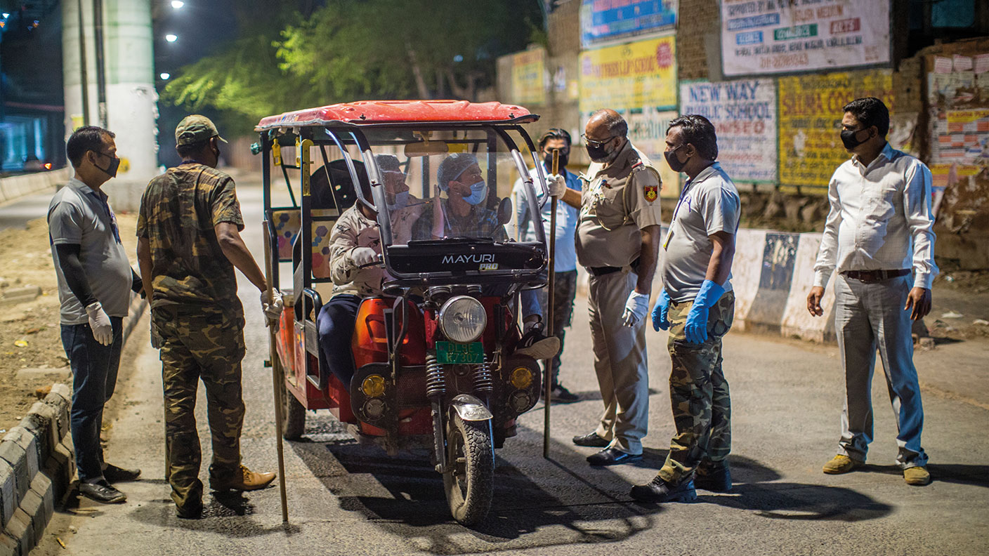 Indian policemen stop a rickshaw 