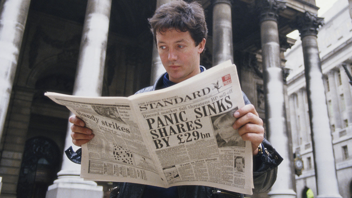 Man reading a paper on &quot;Black Monday&quot; in 1987