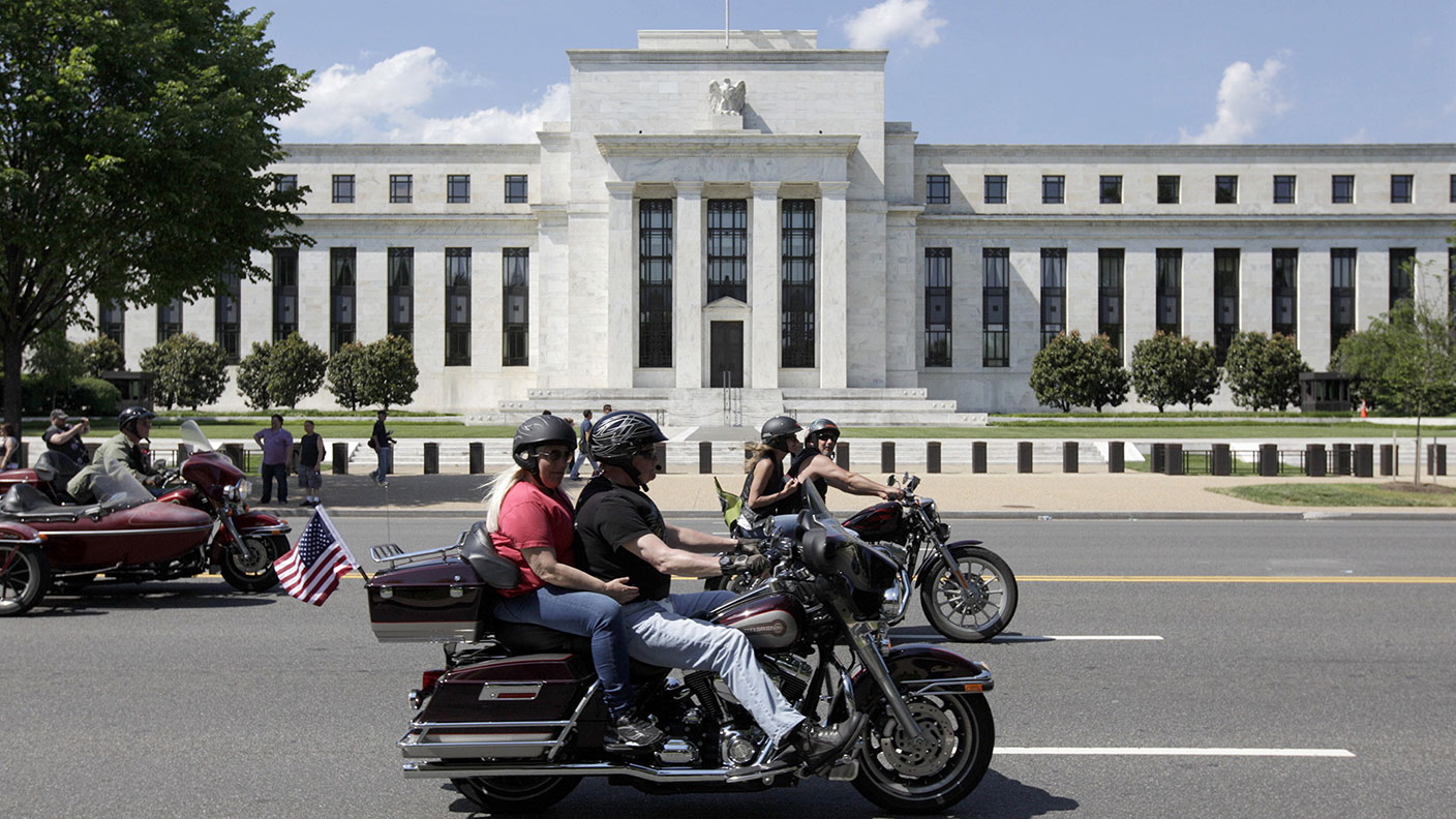Motorcyclists ride by the US Federal Reserve Building
