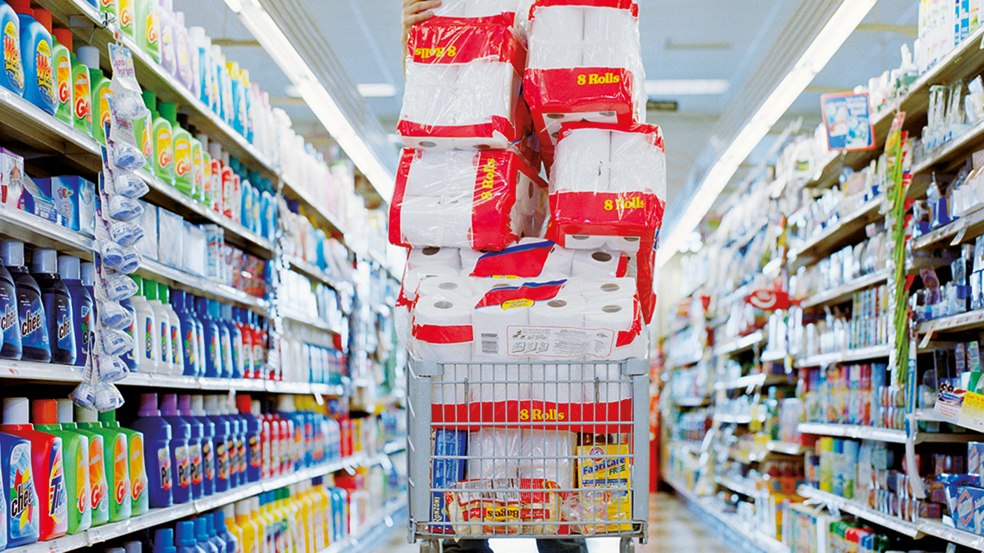 A shopping trolley piled up with toilet rolls