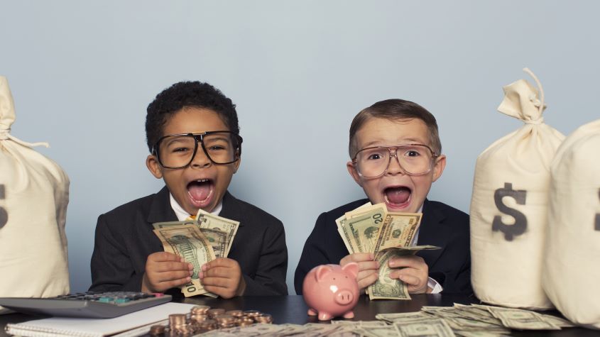 Two children wearing suits and holding money