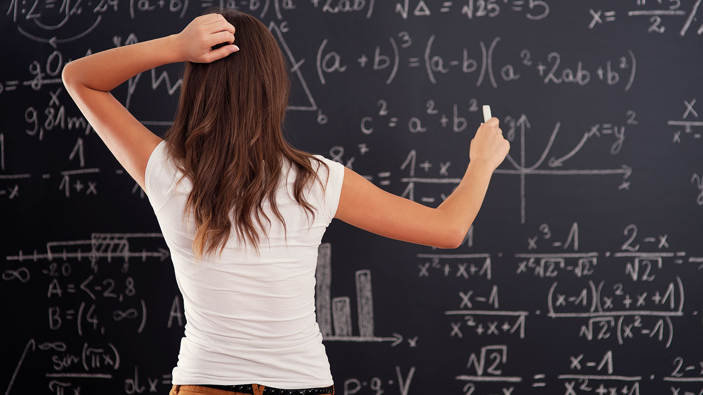 Woman looking at a blackboard with random “maths” on it