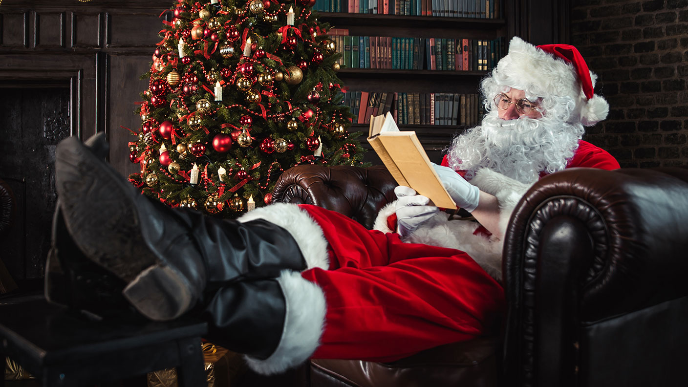 Father Christmas with his feet up reading a book