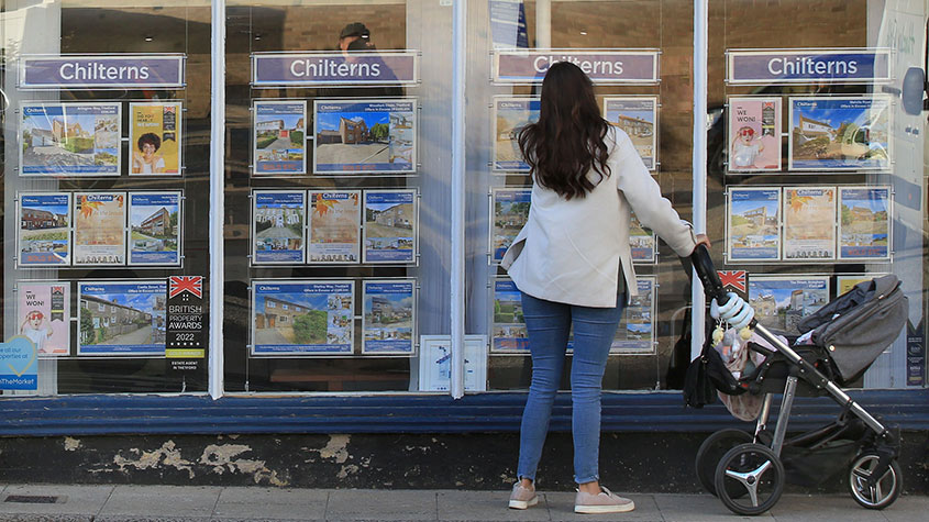 Woman looking in an estate agent&#039;s window