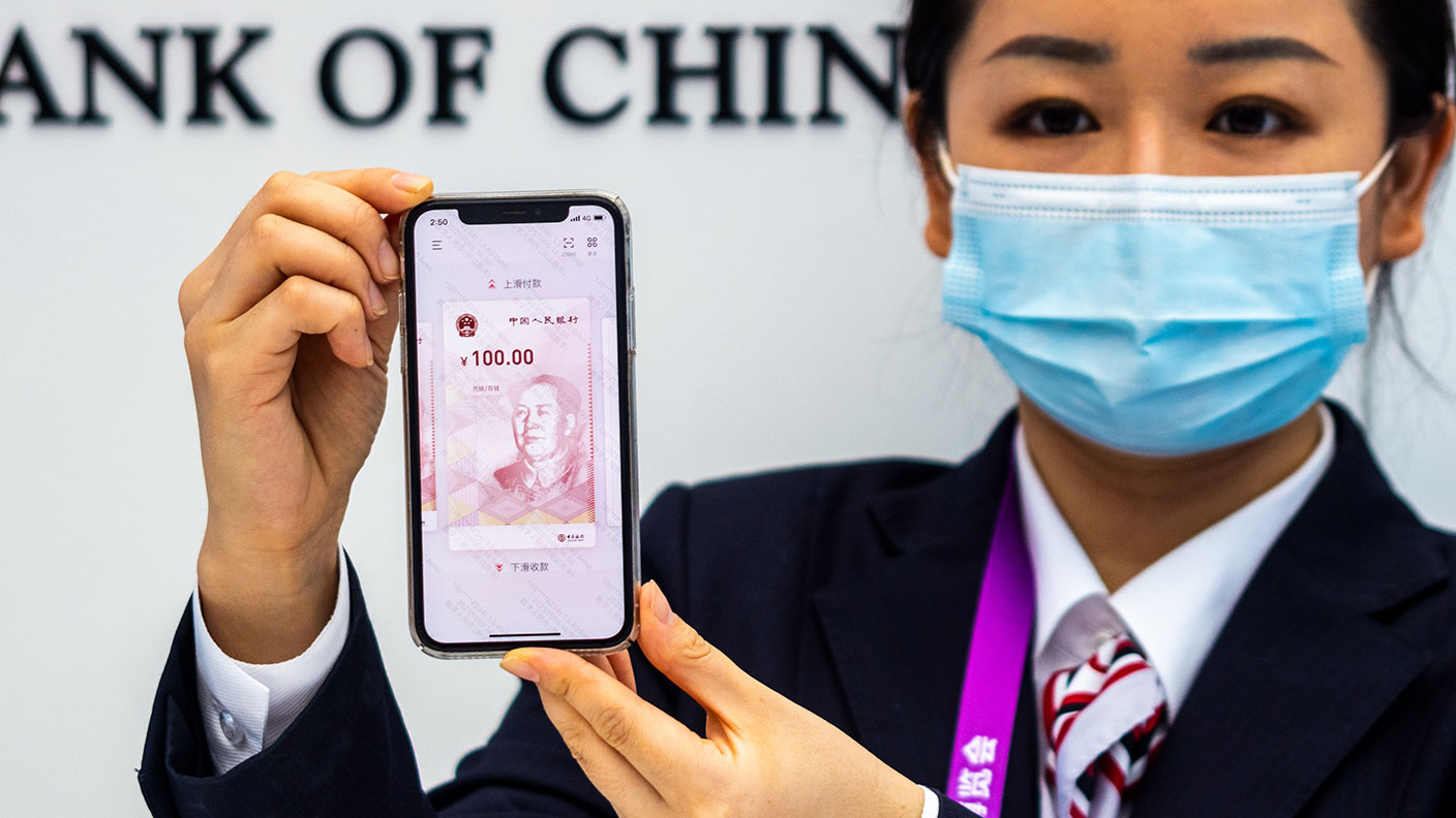 A worker shows China&#039;s digital currency on a smartphone