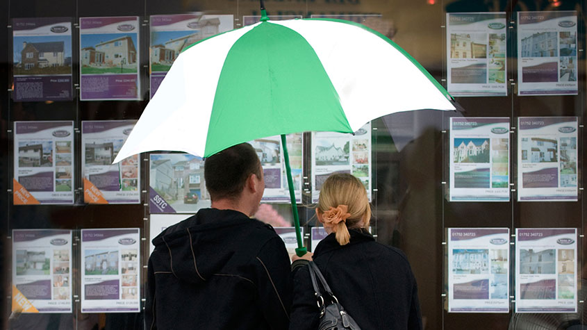Couple looking in an estate agent&#039;s window