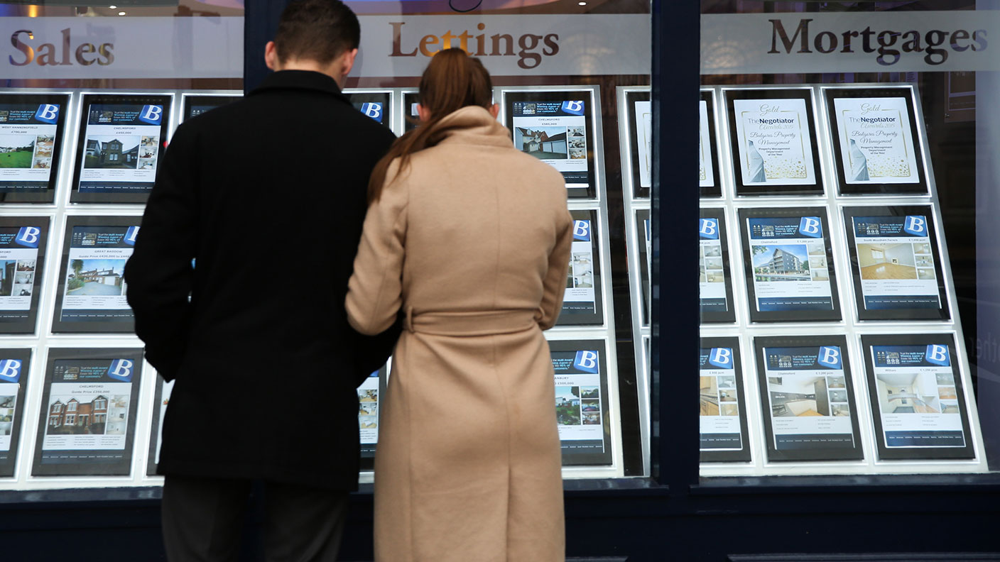 Couple looking in an estate agent&#039;s window